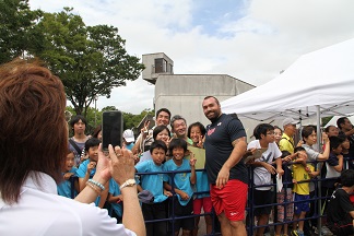 世界陸上アメリカ代表選手と子どもたちが写真撮影でポーズをとっている様子