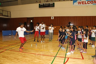 楽しそうに世界陸上アメリカ代表選手と体を動かしている小学生の様子