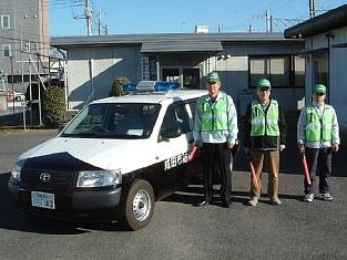 パトロール車の前に3名立っている様子