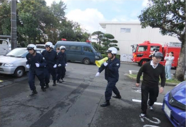 自主防災訓練の様子7。隊長の指示で救出階に向かう成田警察署員。