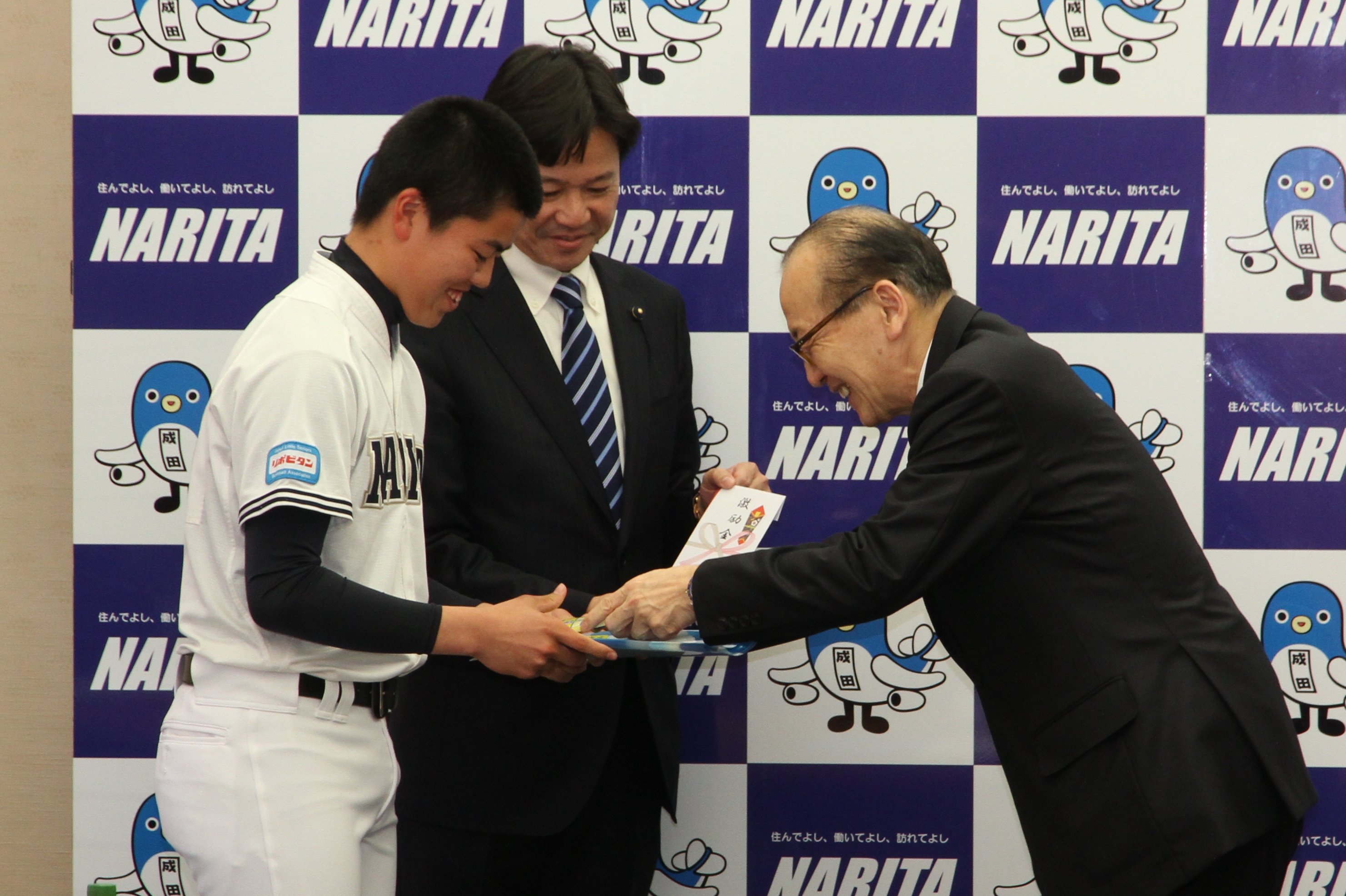 成田リトルシニア　第24回日本リトルシニア全国選抜野球大会　出場激励会　市長が激励品を贈呈する様子