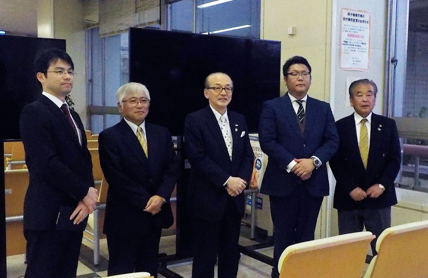 テレビモニター前で小泉市長と成田グリーンライオンズクラブの皆さまの写真