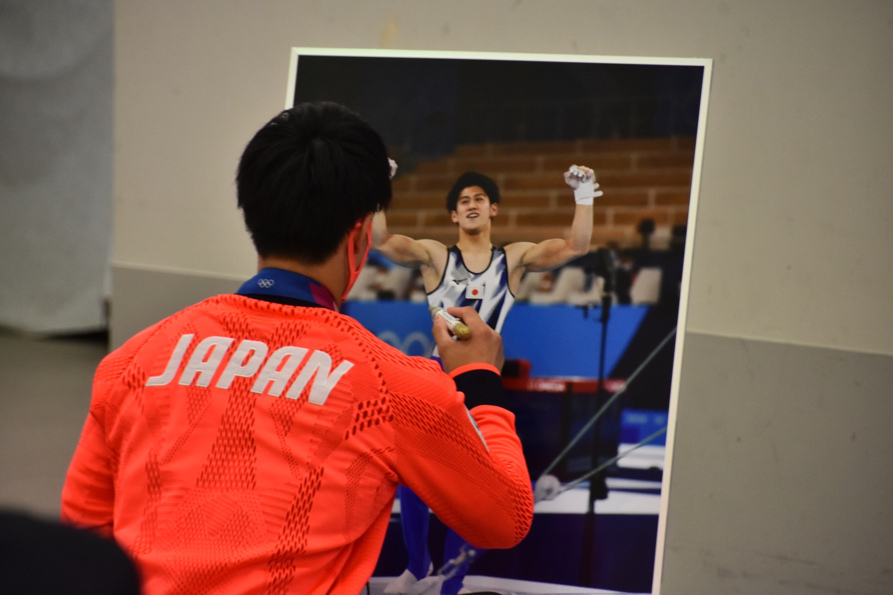 写真パネルにサインをする橋本選手