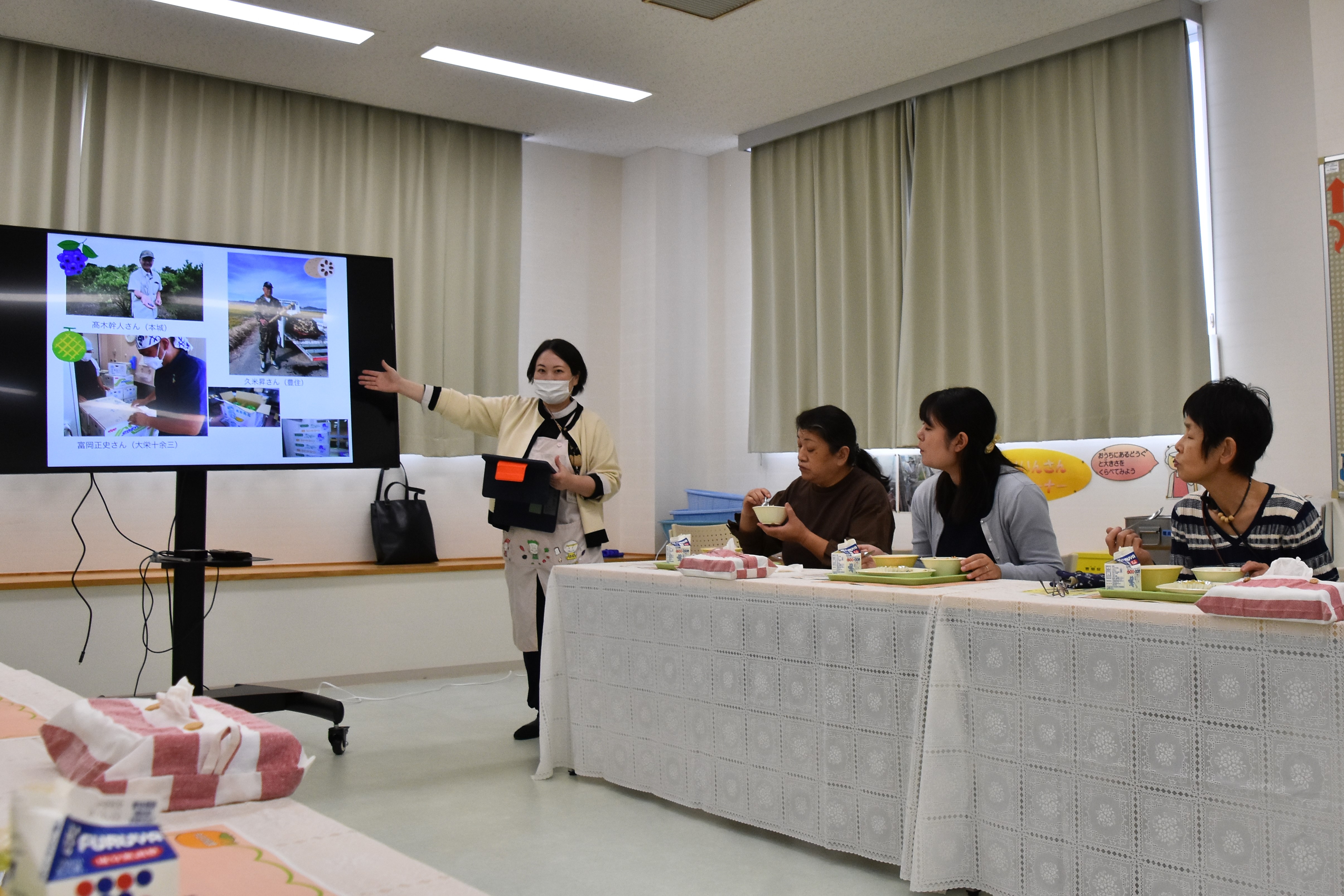 給食を食べながら栄養士の話を聞く様子の写真