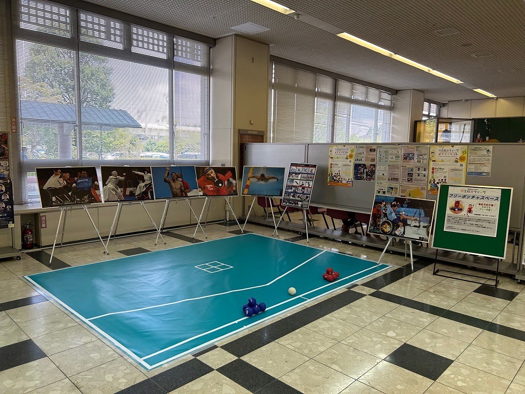 市役所1ロビーに設置されたフリーボッチャと、その周囲でパスポーツを紹介するパネル展示を行っている様子