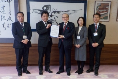 答申書を手に記念撮影を行う様子