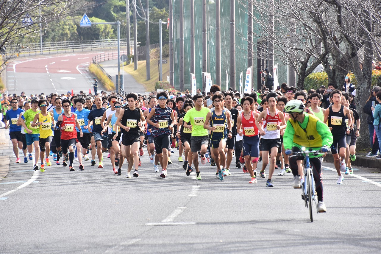 成田ポップラン大会のスタート時の写真。先導の自転車に続き、車道を埋め尽くすほどのランナーが一斉に走り出す様子。