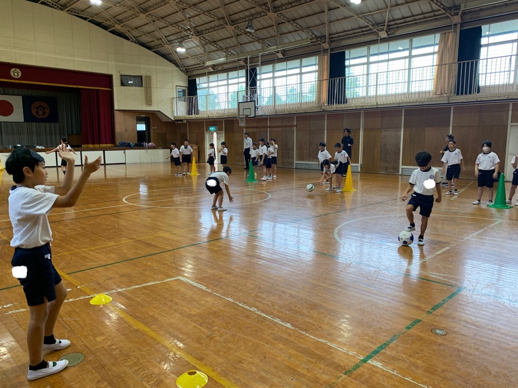 アイマスクを着けた児童が、拍手と呼びかけで方向を案内する仲間に対してパスを出す様子