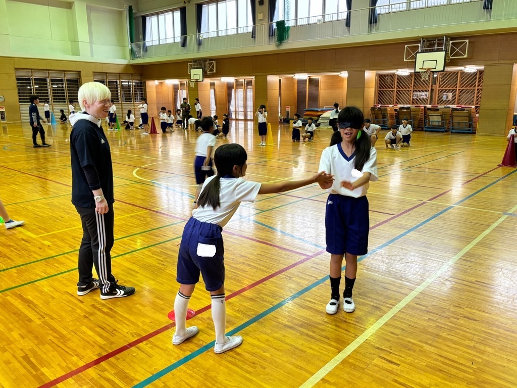 児童がアイマスクをした相手に対して、目的地へたどりつけるように方向や距離などの指示を出して誘導する様子