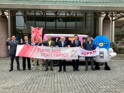 横断幕を手に関係者と記念撮影を行うう様子