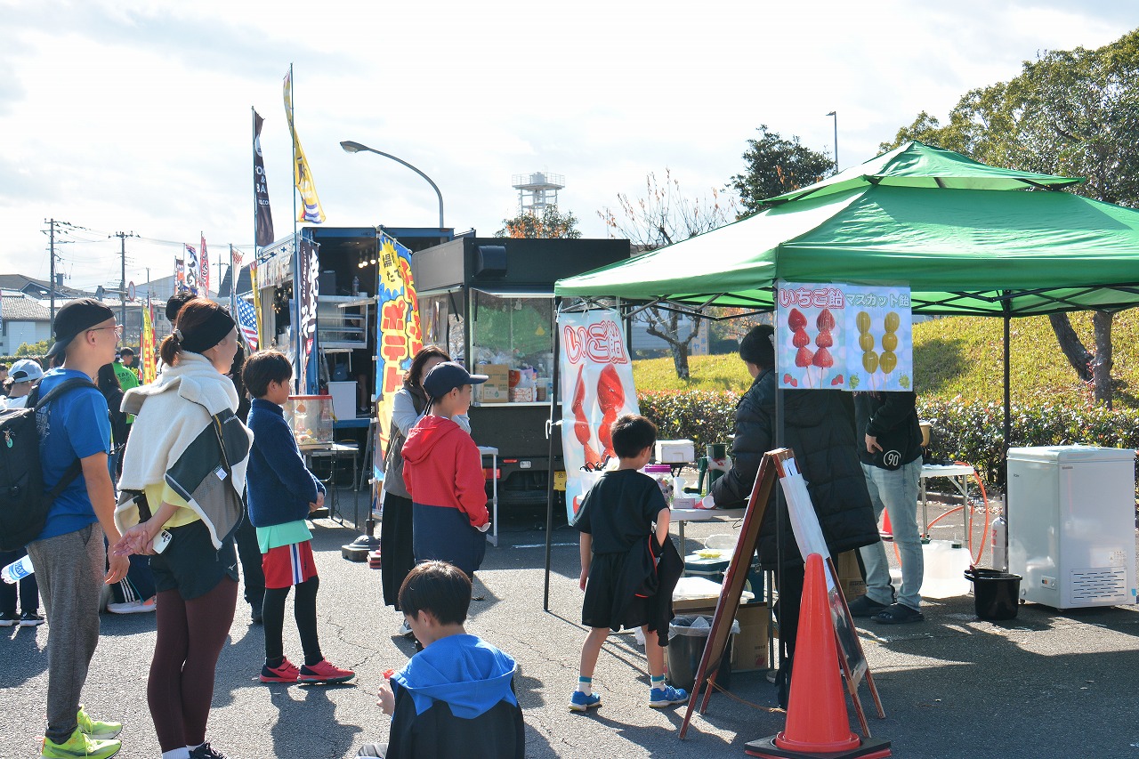 2025成田POPラン大会の会場内に設置された飲食エリアでの様子の写真。走り終わったランナーたちが、食べ物を購入するため並んでいる様子。