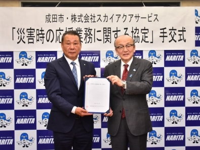 協定書を手に記念撮影を行う様子