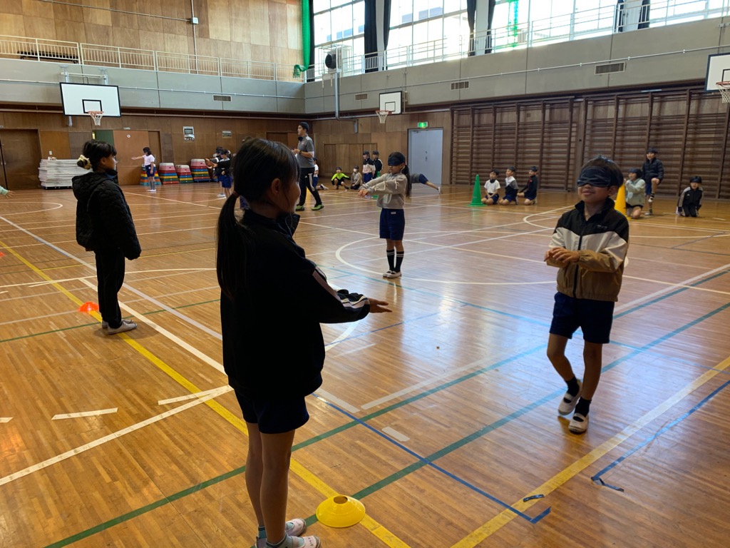 児童がペアを組み、ガイド（案内）役がアイマスクを着けて歩く相手を言葉のみで誘導する様子