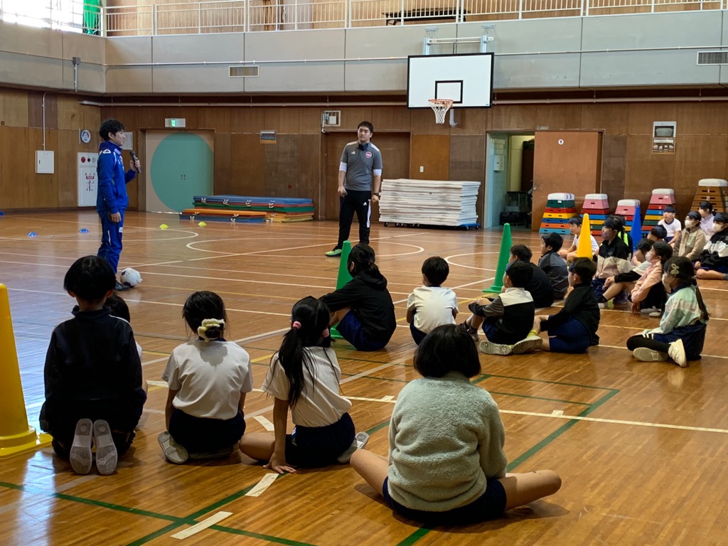 グループごとに並んでいる児童の前で、講師が注意点やポイントを説明している様子