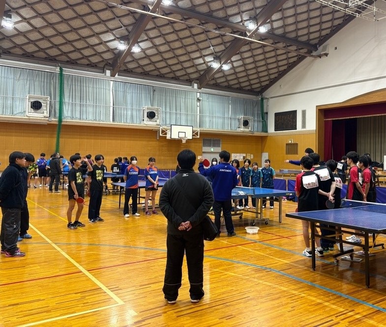 実技指導の様子。選手を囲み、説明を受けている様子。