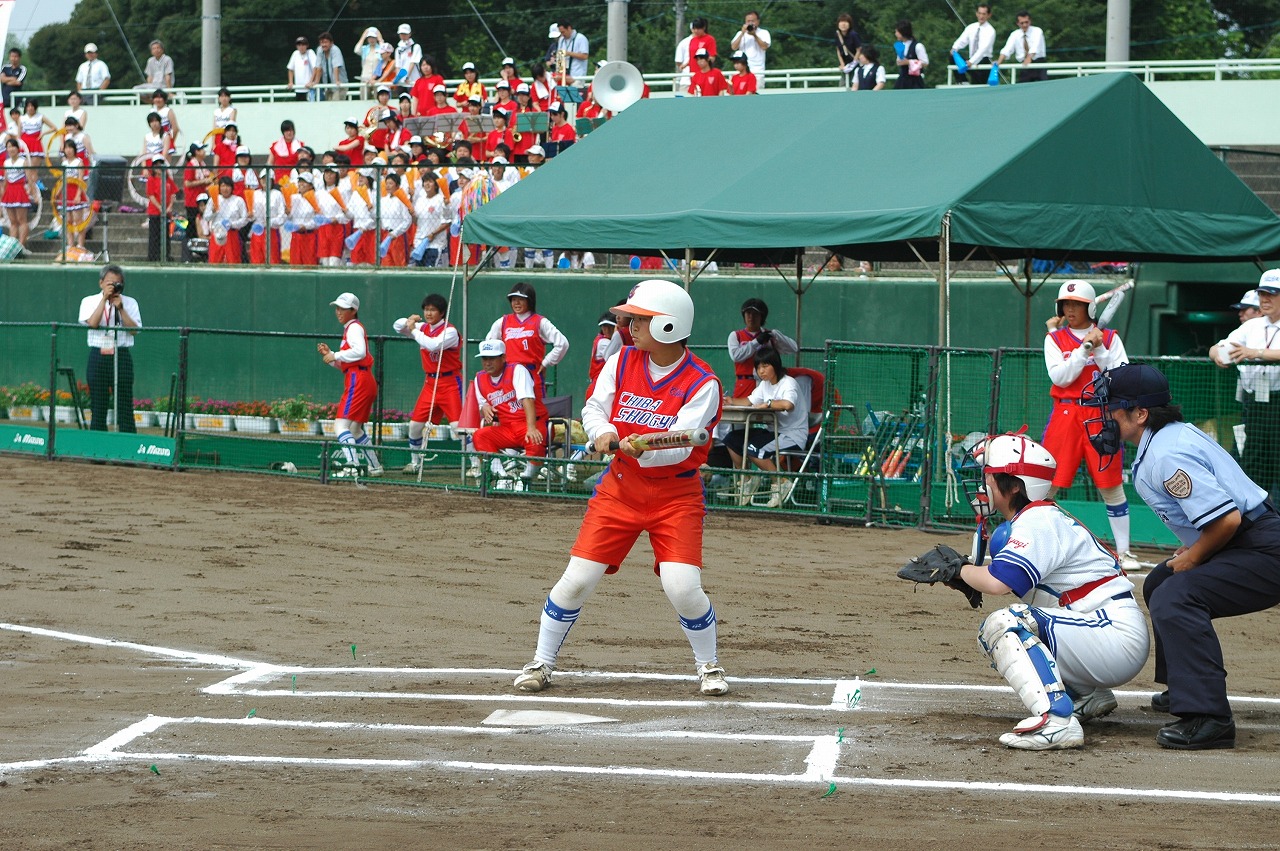 平成17年度に成田市で女子ソフトボール競技を開催した時の写真。千葉県代表で出場した千葉商業高校の攻撃回で選手がバッターボックスに立つ姿をチームメイトや観客が応援している。